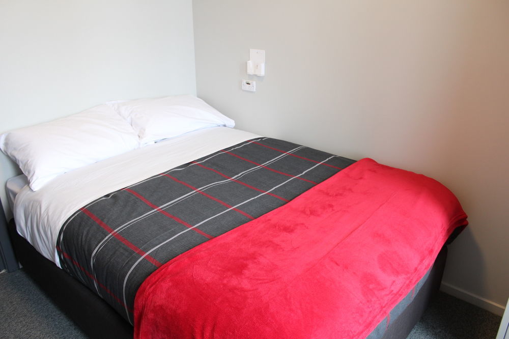 Urbanz Hostel Christchurch Ngoại thất bức ảnh A bed with a throw